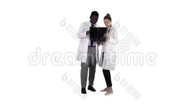 严肃善良的女医生和美国黑人医生在白色背景下研究大脑x光。